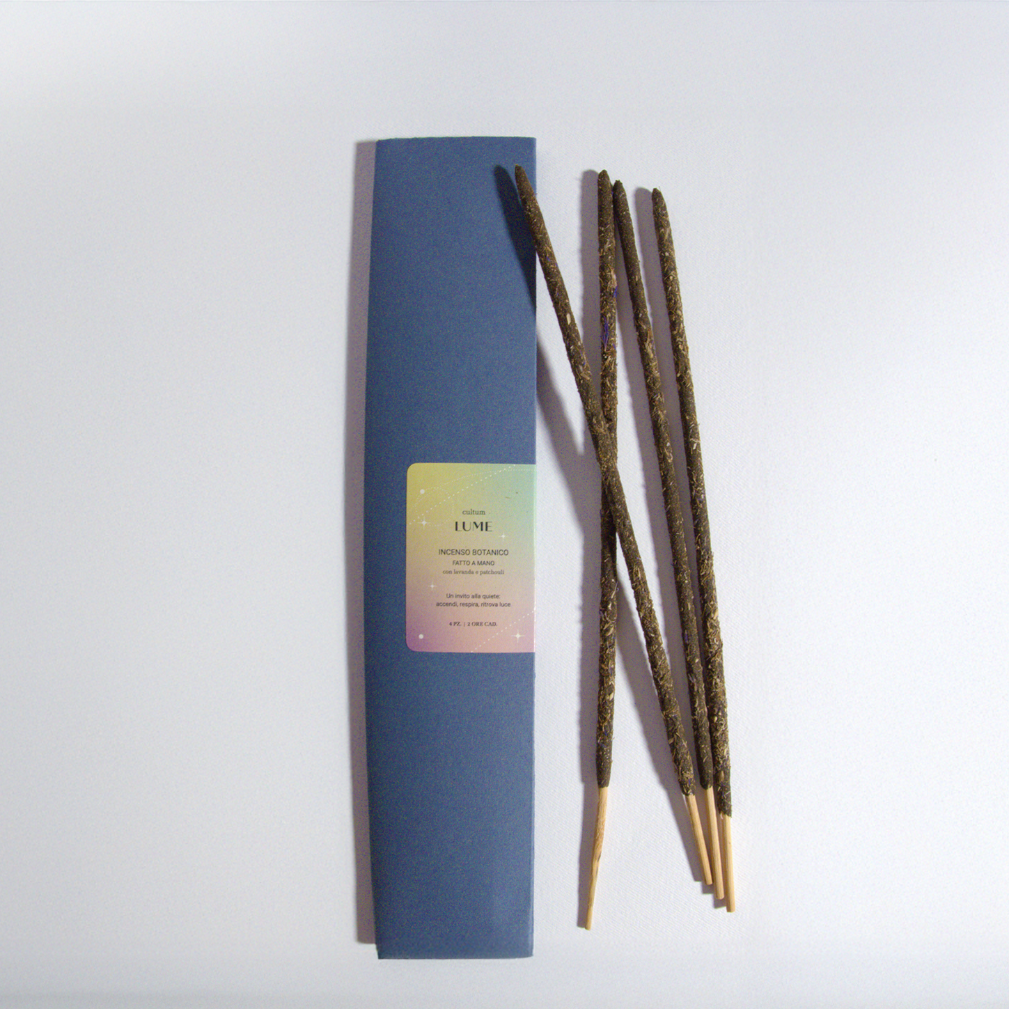 Incensi artigianali Cultum Lume alla lavanda e patchouli, fotografati su superficie neutra con luce naturale. Bastoncini fatti a mano pensati per un rituale di quiete e presenza. Il testo interno alla confezione richiama gli elementi terra, acqua, fuoco e aria, invitando a coltivare silenzio e rendere sacro l’ordinario. Una fragranza botanica e avvolgente che accompagna momenti di meditazione, gratitudine e luce interiore.