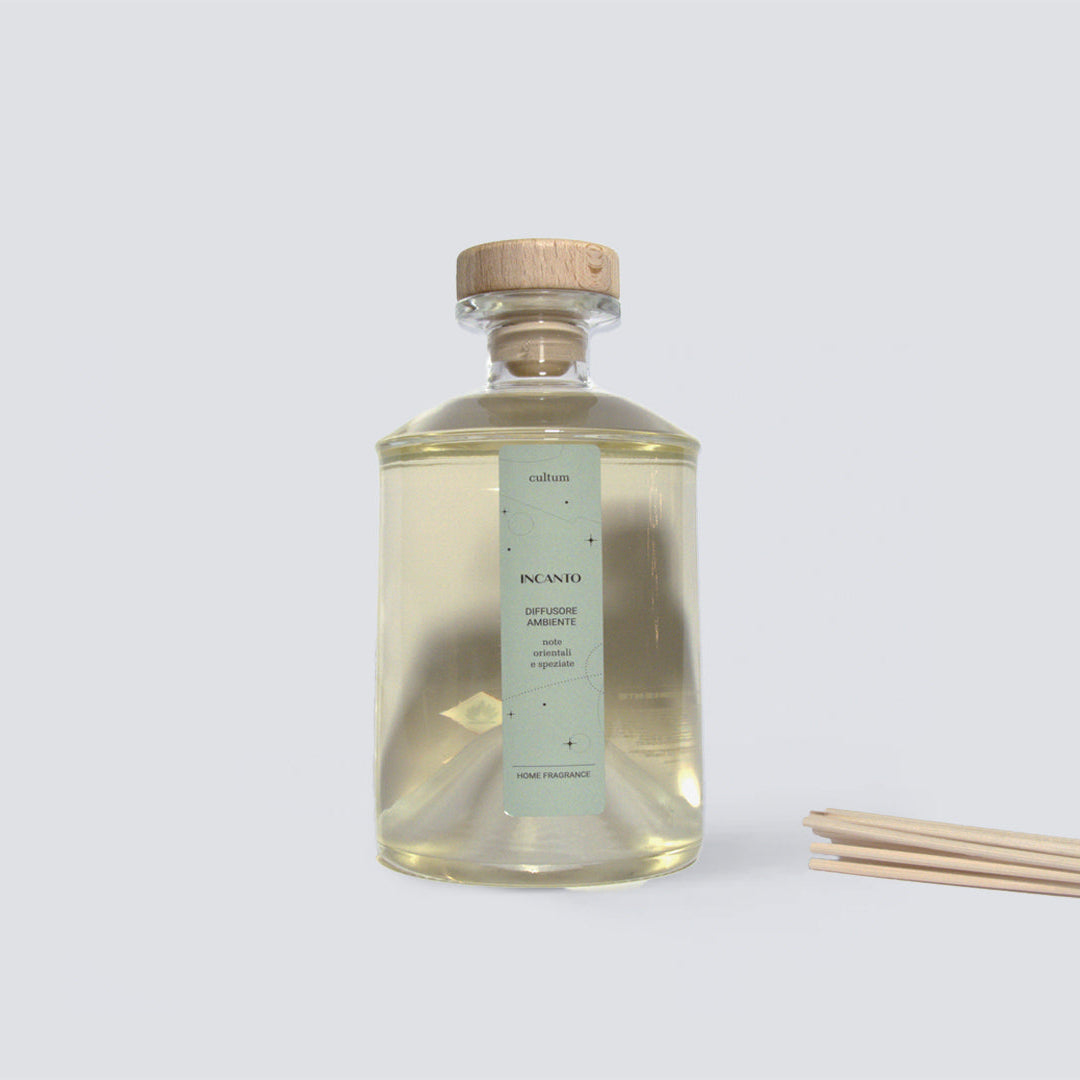 Diffusore ambiente Cultum Incanto con bastoncini in rattan, fotografato su superficie neutra con luce naturale. Bottiglia dal design essenziale e fragranza orientale e speziata con note di incenso, mirra e pepe. I bastoncini in rattan assicurano una diffusione costante e regolabile, trasformando l’ambiente in uno spazio caldo, avvolgente e ricco di atmosfera.