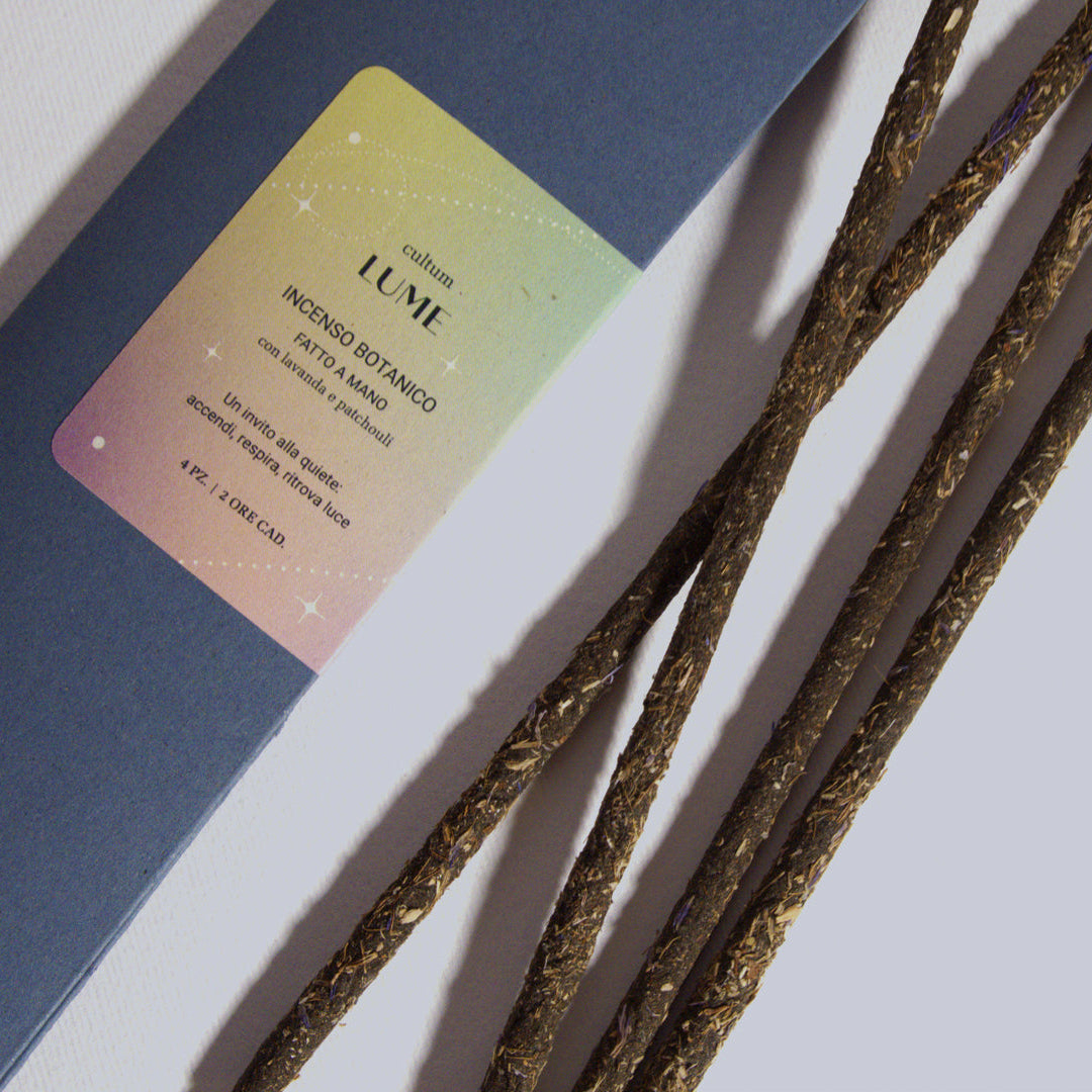 Incensi artigianali Cultum Lume alla lavanda e patchouli, fotografati su superficie neutra con luce naturale. Bastoncini fatti a mano pensati per un rituale di quiete e presenza. Il testo interno alla confezione richiama gli elementi terra, acqua, fuoco e aria, invitando a coltivare silenzio e rendere sacro l’ordinario. Una fragranza botanica e avvolgente che accompagna momenti di meditazione, gratitudine e luce interiore.
