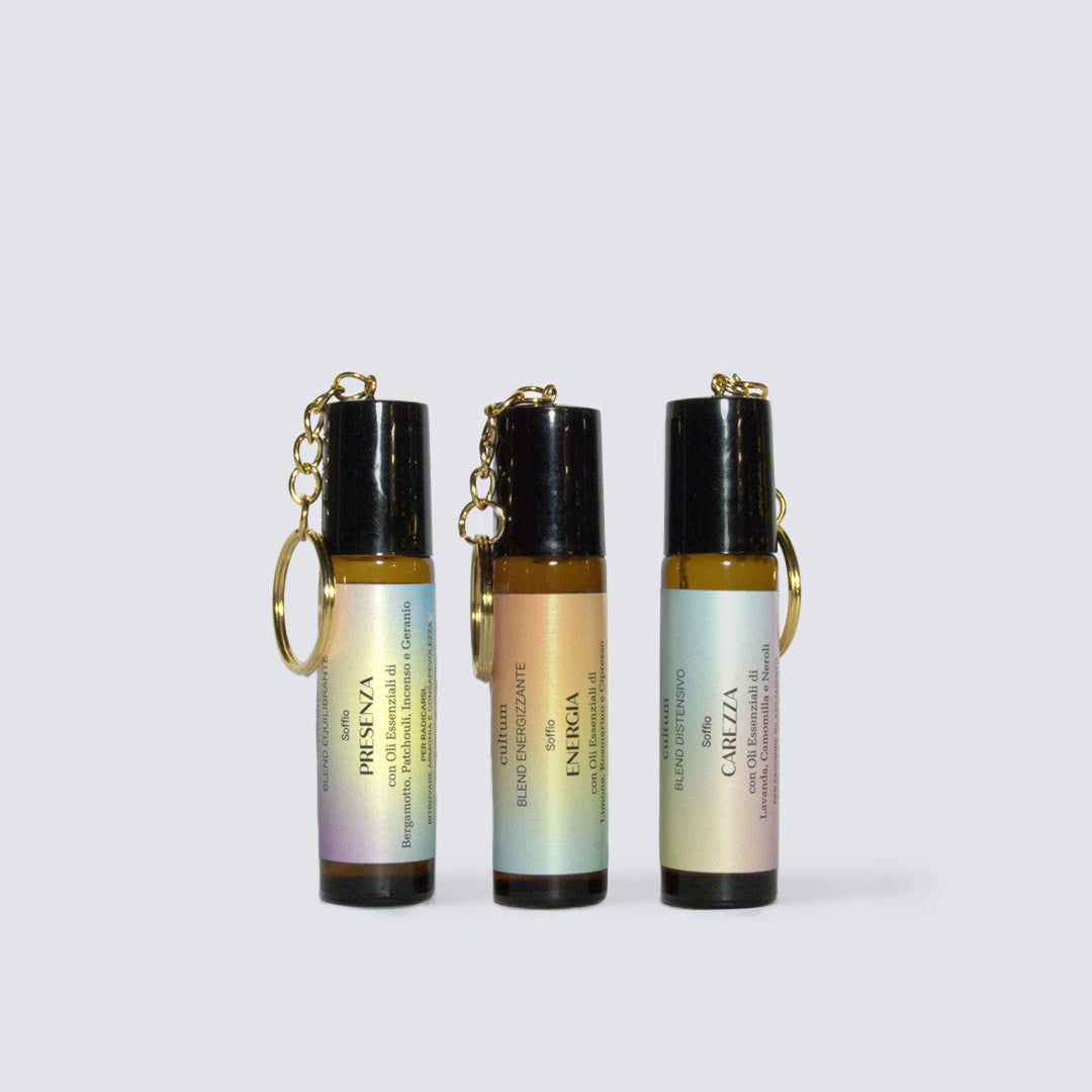 Immagine dei tre roll-on botanici Cultum – Carezza, Presenza ed Energia – disposti in verticale, con packaging minimale, tappo con catenella per attaccarlo alla borsa.